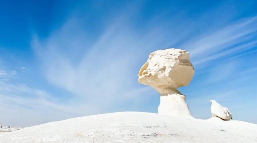 Peaceful and vast expanse of the White Desert's white formations, accessed from Bahariya Oasis, under a clear desert sky
