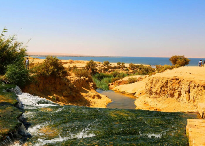 The impressive waterfalls of Wadi El Rayan, with water flowing between two lakes against a backdrop of golden desert dunes in Fayoum