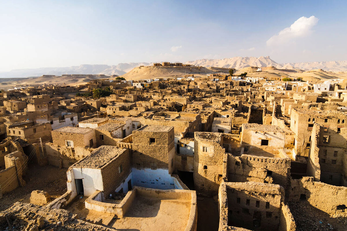 Dakhla: Calles que Susurran Historias de Siglos Calles estrechas y casas de adobe de una aldea histórica en el Oasis de Dakhla, como Al-Qasr, mostrando su arquitectura islámica medieval