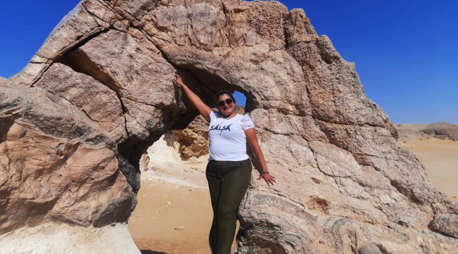 Un touriste posant près des imposantes formations cristallines de la Montagne de Cristal, montrant l'échelle du site