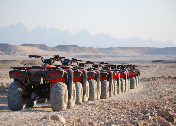 Un groupe de quads roulant à toute vitesse dans le désert égyptien