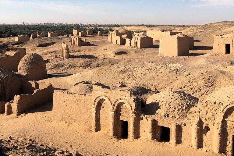 Kharga: Latidos de Vida en el Corazón del Oasis Ruinas antiguas o templos históricos en el Oasis de Kharga, como el Templo de Hibis, rodeados por el paisaje desértico y el verdor del oasis