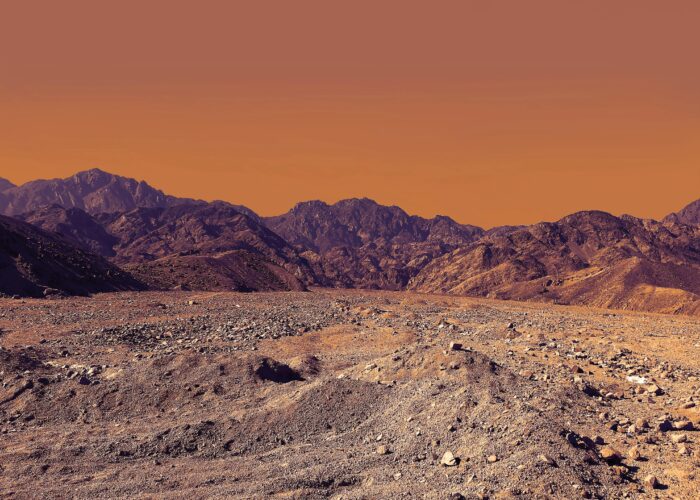 Vasta distesa del deserto del Sinai con imponenti montagne rocciose che si ergono all'orizzonte, sotto un cielo ampio