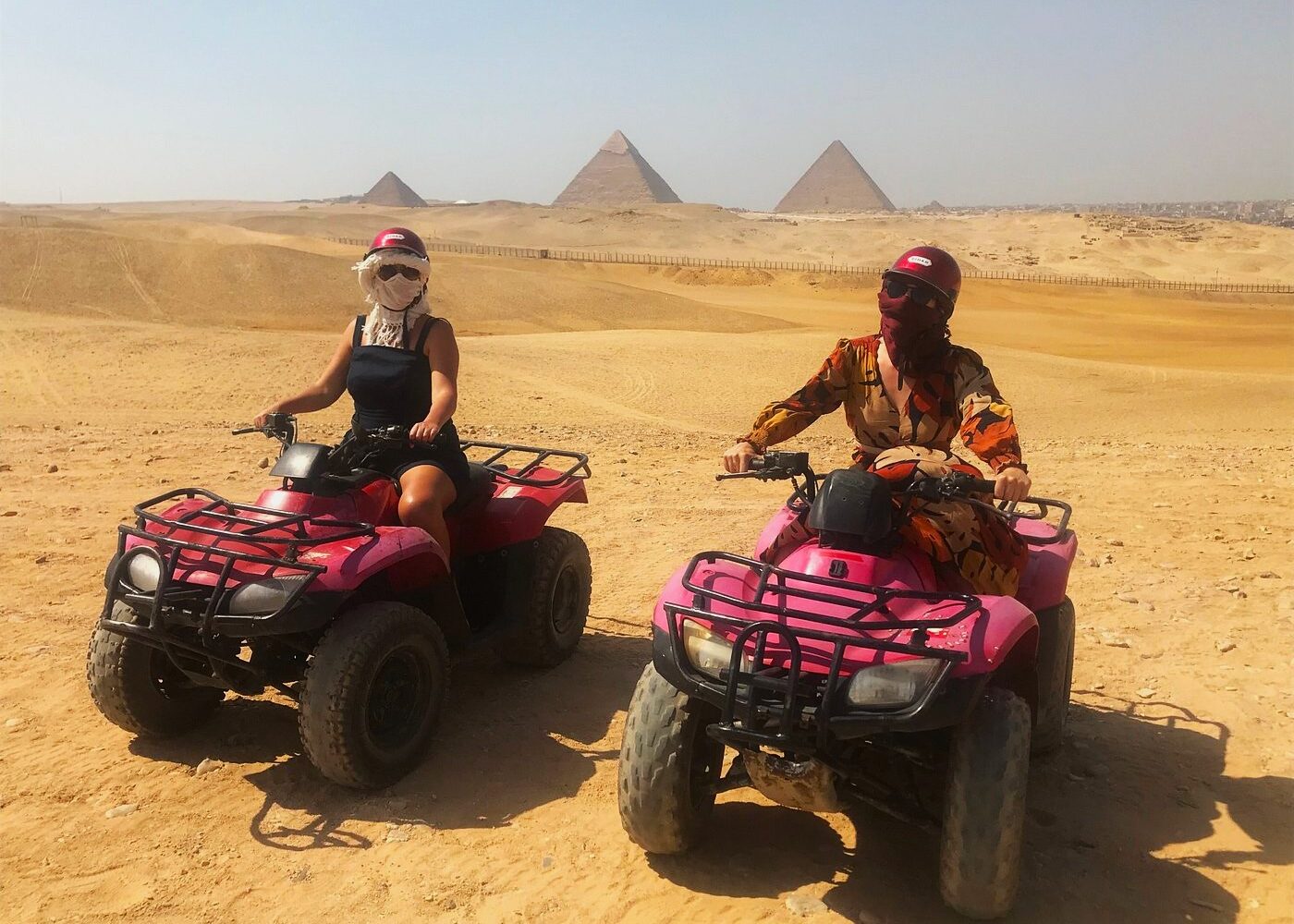 Des touristes conduisant des quads près des pyramides de Gizeh
