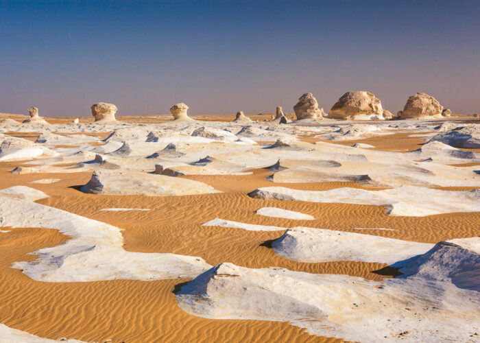 Formações rochosas de giz branco esculpidas pelo vento, assemelhando-se a cogumelos gigantes e icebergs, estendendo-se no Deserto Branco do Egito